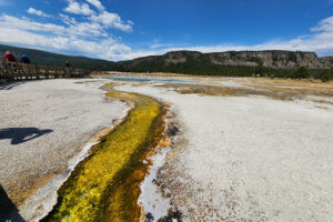Overflow of beautifully colored minerals heading to the Firehole River in Yellowstone National Park with Get Lost in America
