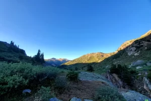 Lights shadows over an alpine valley as it embraces rays of dawn as the chill of the night slides away over the terrain with suns approach